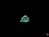 a close up of a green diamond on a black surface