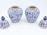 three blue and white vases sitting next to each other on a white surface