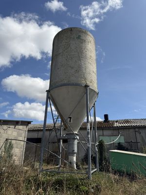 a large cement silo in the middle of a field