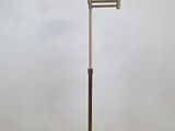 une photo d'un lampadaire en laiton posé sur un parquet
