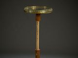 an antique brass plate on a wooden stand against a black background