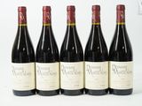 six bouteilles de vin sont alignées sur une table