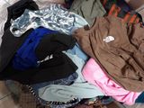 a pile of clothes that is on a bed