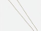 un collier blanc composé d'une chaîne à boules en argent et d'une boule en argent