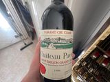 a person holding a bottle of red wine in their hand