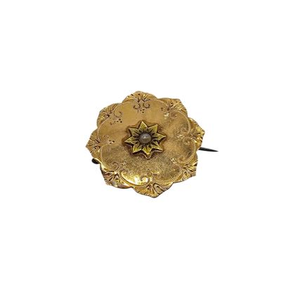 a gold flower brooch with a diamond in the center