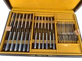 many forks and spoons in a case on the table