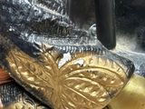 a close up of a helmet with a gold decoration on it