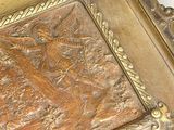 a picture of a gold plate with a picture of a bird on it