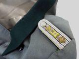 a lapel of a man in a suit with a green tie