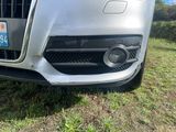 une voiture garée dans l'herbe et munie d'une plaque d'immatriculation
