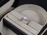 une bague en diamant dans un écrin posé sur une table