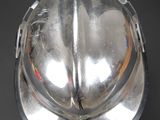 a shiny silver helmet on a black surface