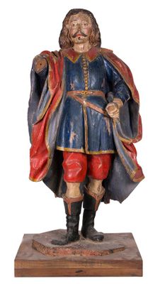 statue d'un homme vêtu d'un manteau bleu et d'un pantalon rouge, tenant une épée