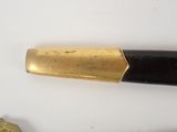 a black and gold pen sitting on top of a white table