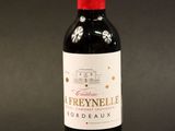 a bottle of red wine sitting on top of a black table