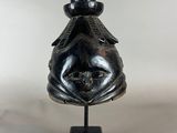 un gros plan d'une sculpture représentant un poisson posée sur un socle