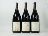 trois bouteilles de vin sont alignées sur une table