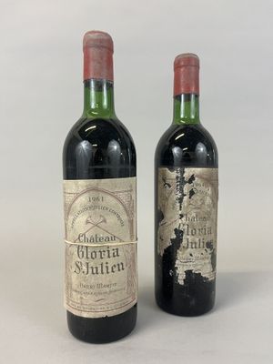 two bottles of red wine sitting next to each other on a white surface