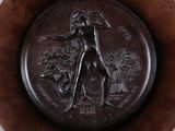 a bronze plate with a woman and a dog on it