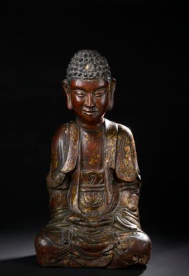 a bronze figure of a seated buddha on a black background