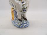 a ceramic figurine of a man sitting on a stool