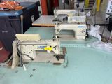 two sewing machines sitting on a table in a room