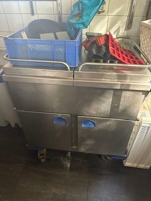 une cuisine avec un évier en métal sur lequel est posé un panier bleu