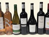 several bottles of wine are lined up in a row on a white surface