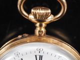 a gold clock with roman numerals on the face