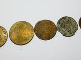 cinq types de pièces différents sont disposés en rangée sur une surface blanche