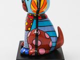 a colorful dog figurine sitting on top of a black base
