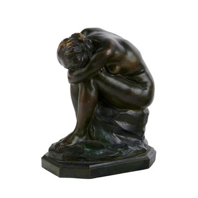 statue d'un homme assis sur un rocher, la tête dans les mains