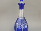 une bouteille en verre bleue décorée de fleurs blanches