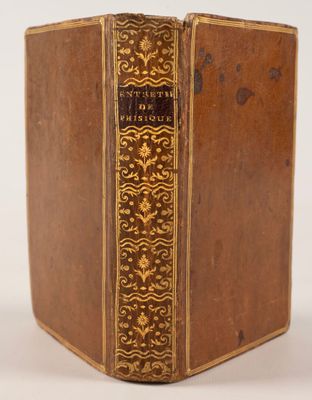 un vieux livre aux tranches dorées et à la couverture marron