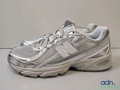 the new balance 990 is a white and silver running shoe