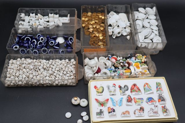 Deux boites avec des fèves et miniatures et accessoires porcelain...