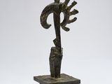 a bronze sculpture of a bird on a branch on a marble base