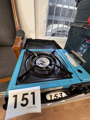 a blue stove sitting on top of a wooden table