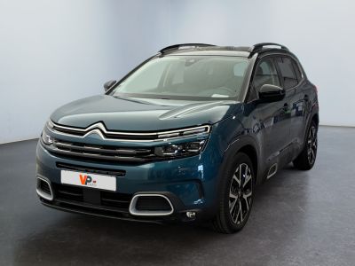 La Citroën bleue est garée dans une pièce au sol noir.