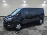 Une camionnette noire est garée dans une pièce au sol carrelé en damier.