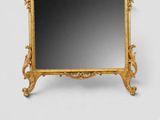 an image of a gold framed mirror sitting on top of a table