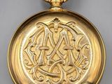 a close up of a gold pocket watch on a white surface