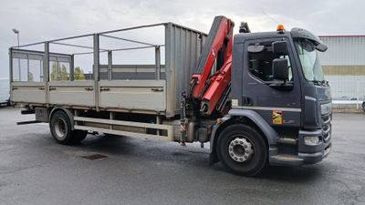 un camion équipé d'une grue à l'arrière, dans un parking