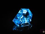 a close up of a blue diamond on a black surface