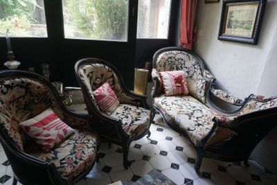 trois chaises et une table dans une pièce carrelée de noir et blanc