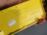 a person holding a yellow plastic box with a sticker on it
