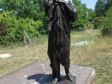 une statue représentant un garçon tenant un appareil photo posé sur une table