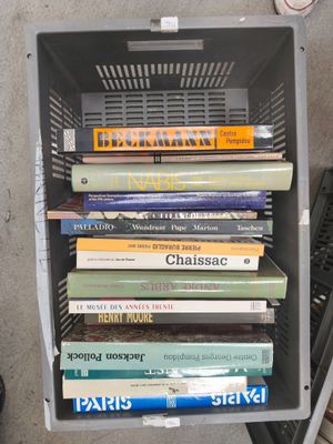 a stack of books sitting on top of a metal crate