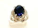 une image d'une bague avec une pierre bleue entourée de diamants